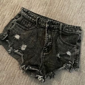Black pair of ripped jean shorts.